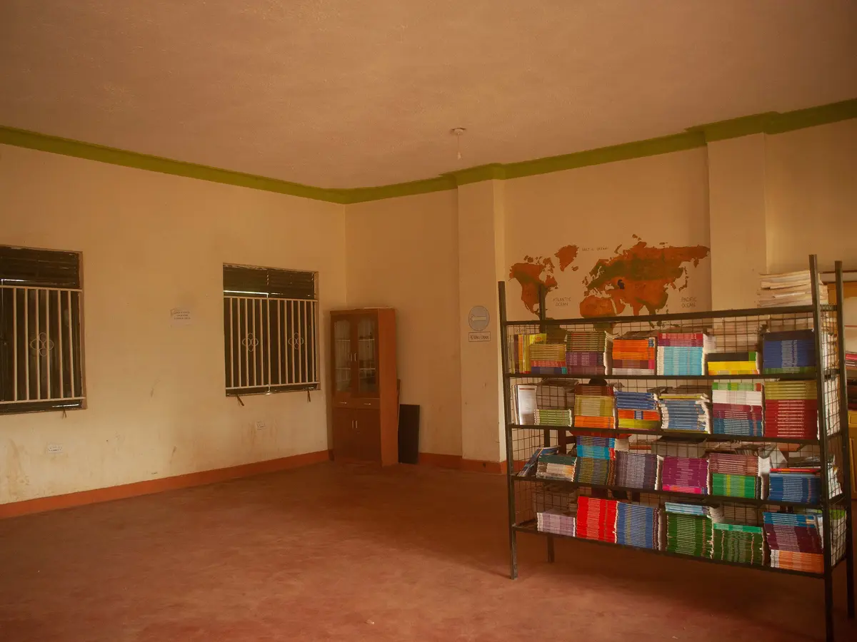 A bright, empty room with a bookshelf and a polished floor